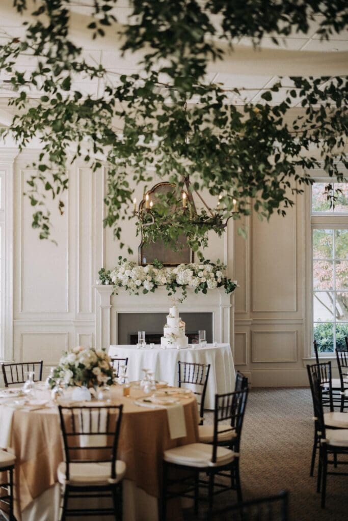 Reception space at TPC Sugarloaf with hanging greenery installation and floral mantle design