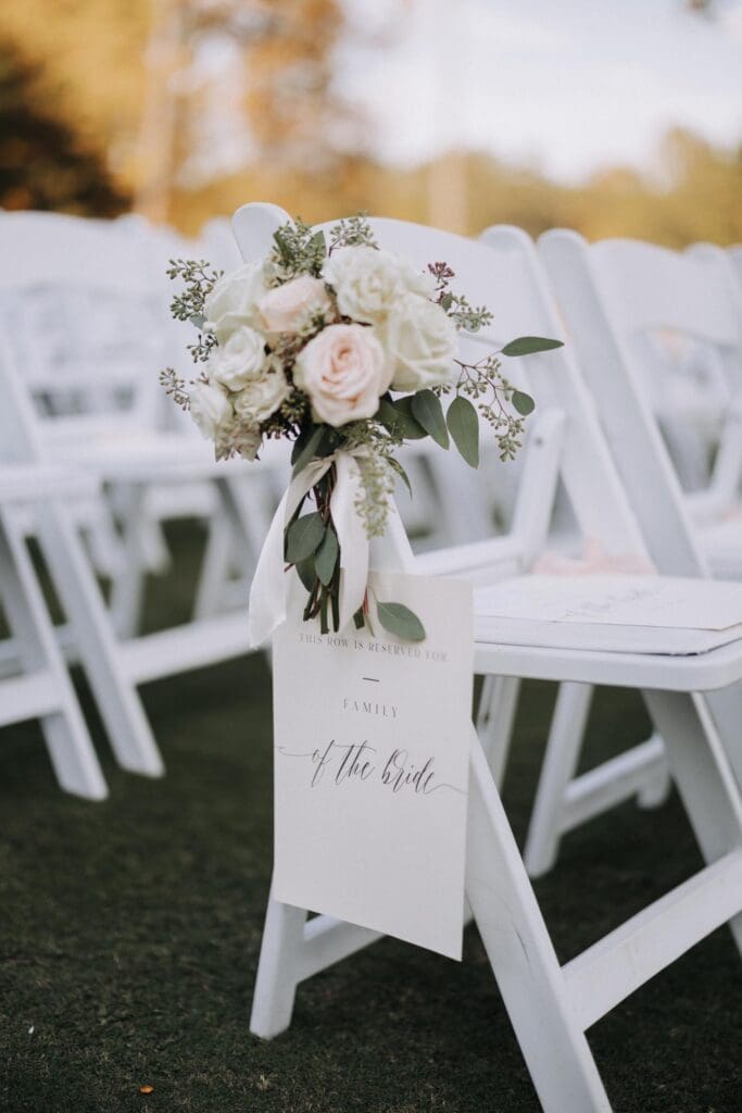 Ceremony aisle chair decorated with blush roses and greenery for TPC Sugarloaf wedding ceremony