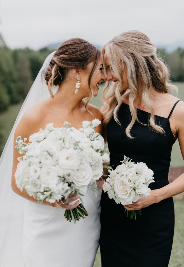 Bride and bridesmaid holding coordinating white garden style bouquets North Georgia wedding
