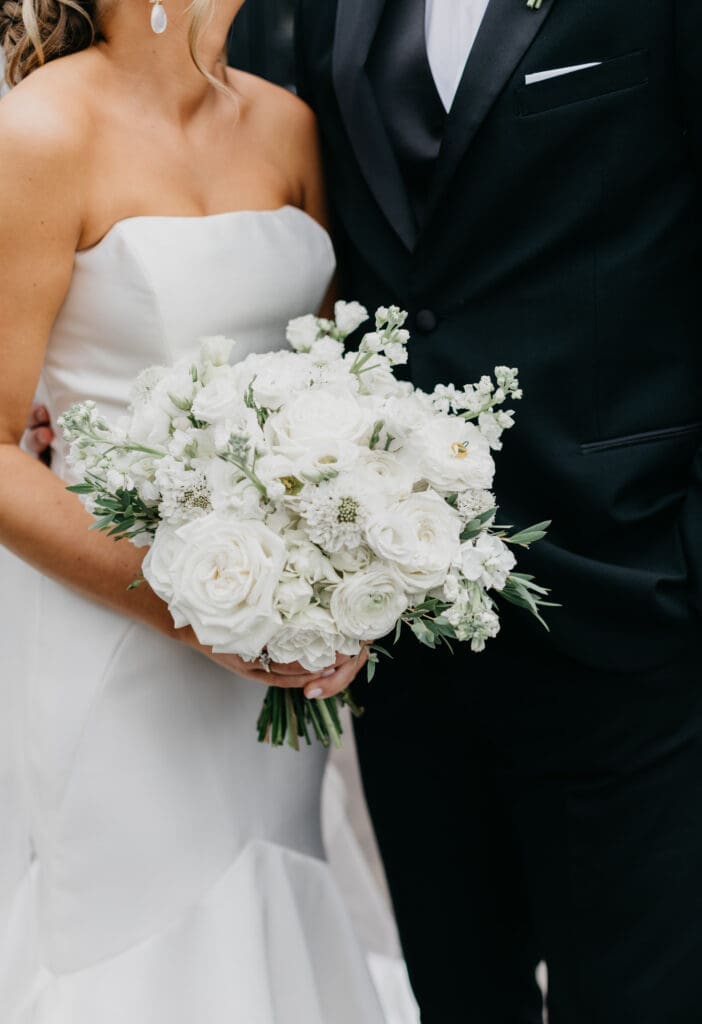 Close up of all white bridal bouquet with roses ranunculus and textured blooms designed by a North Georgia luxury wedding florist