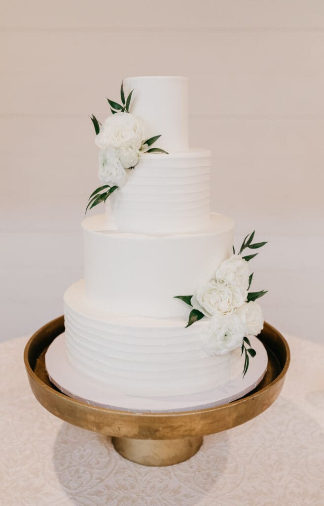 Four tiered wedding cake with simple floral accents