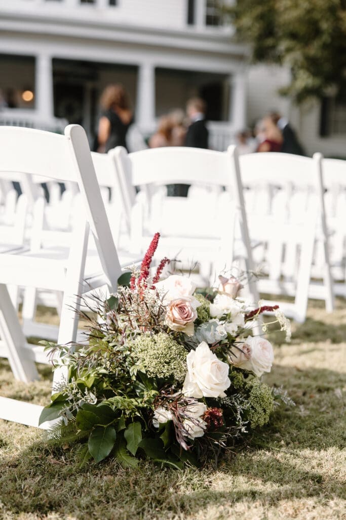 Garden-style ceremony floral arrangements enhancing historic Payne-Corley House venue