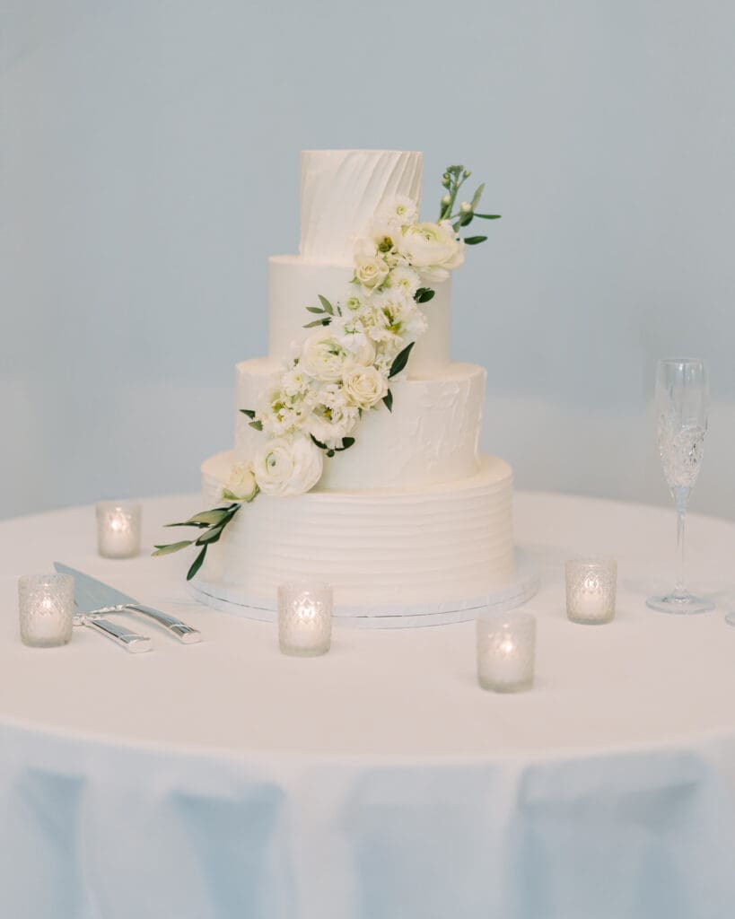 All white wedding cake with cascading florals