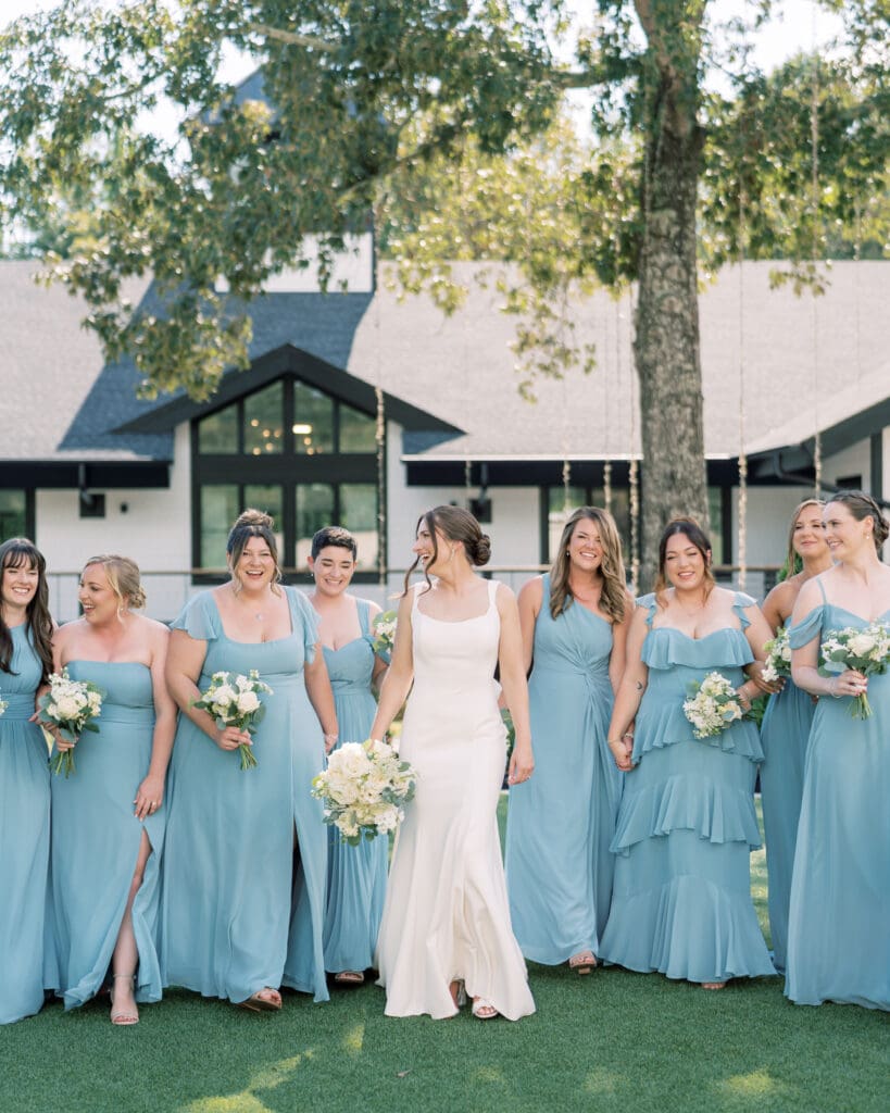 Bride and bridesmaids at The Revere in Atlanta holding custom white rose bouquets with soft eucalyptus accents