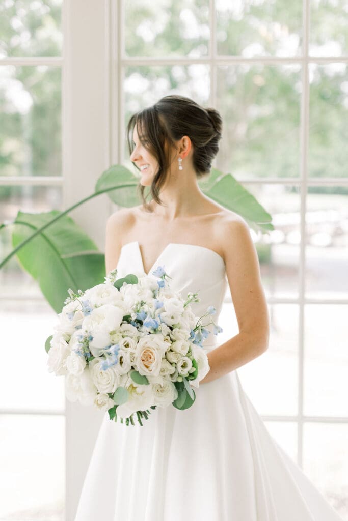 Bride holding lush white and blue bouquet at TPC Sugarloaf 
