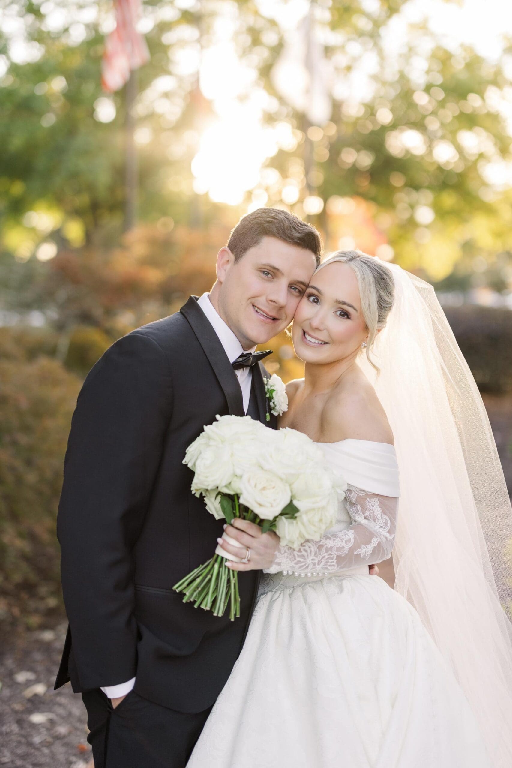 Bride and groom portrait at TPC Sugarloaf with sunset lighting and white rose bouquet