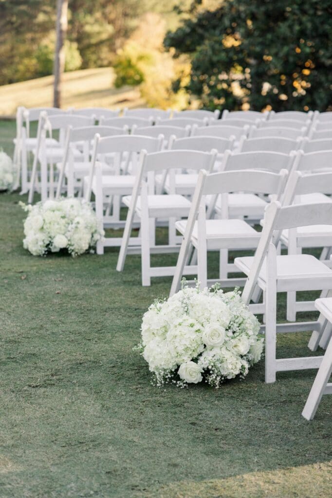 White hydrangea and rose aisle arrangements for outdoor TPC Sugarloaf wedding ceremony