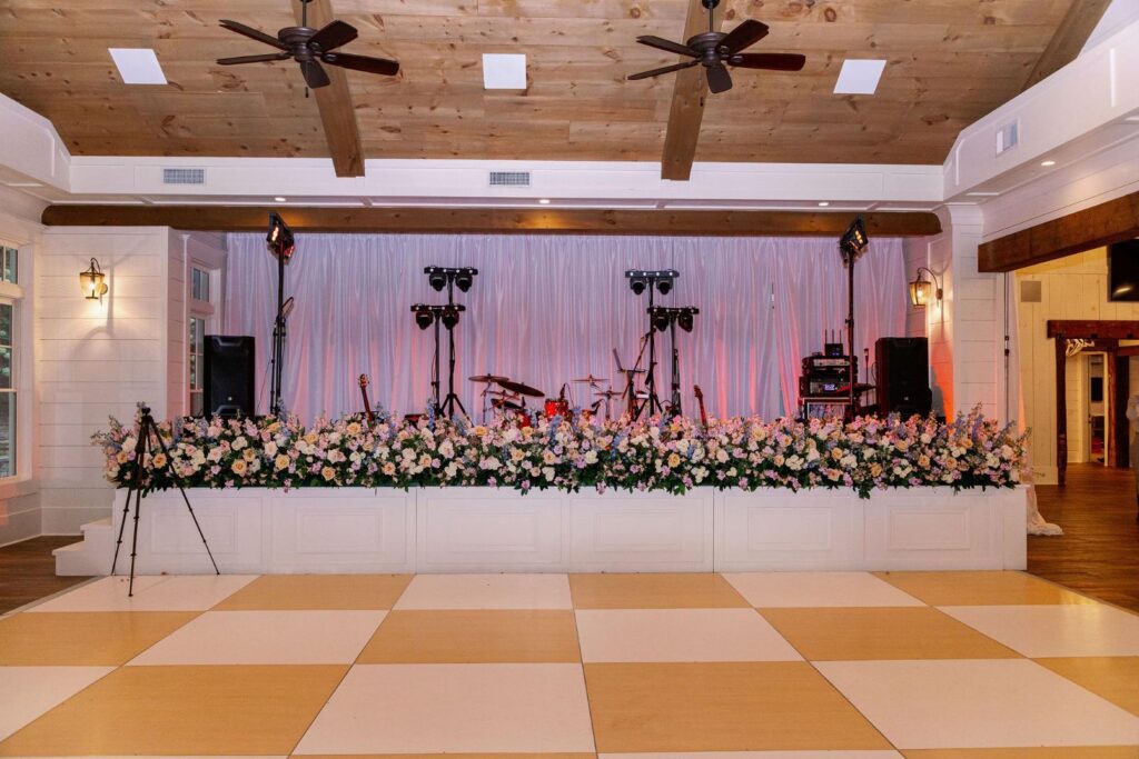 Large pastel floral installation decorating band stage at Greenfield Farm wedding reception