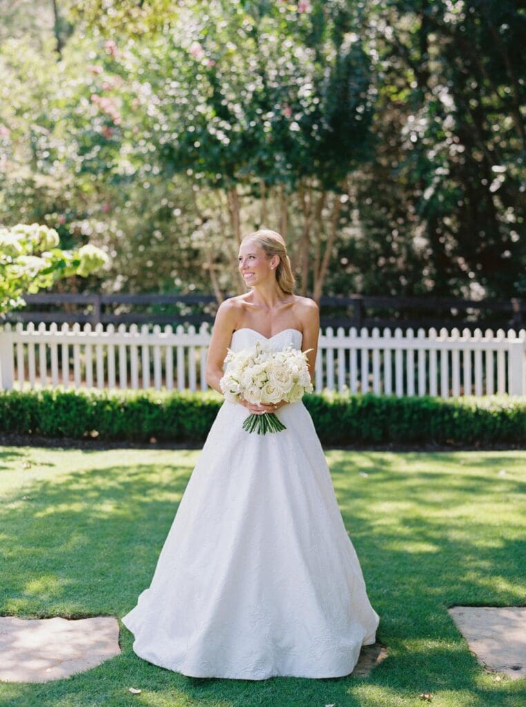 Bride holding white rose bouquet during outdoor portrait at Greenfield Farms