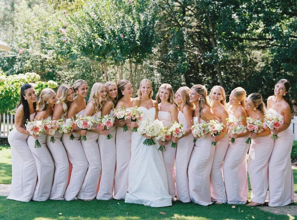 Bridesmaids carrying blush and peach garden rose bouquets during North Georgia wedding