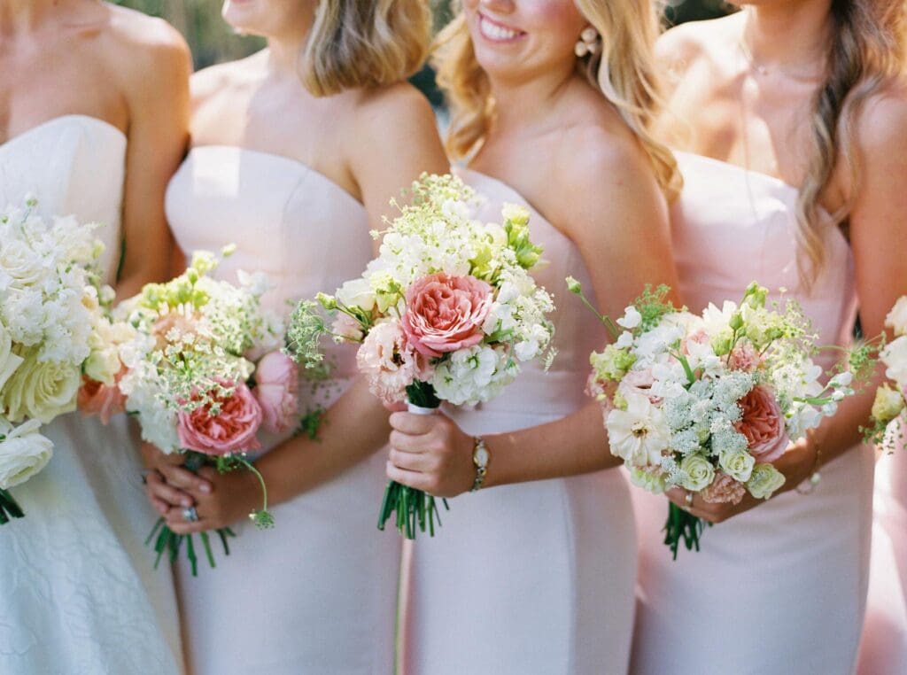 Bridesmaids holding blush and peach garden rose bouquets during Greenfield Farms wedding