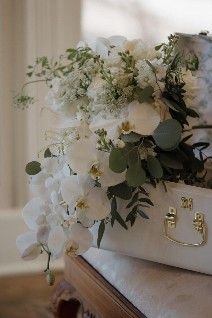 Close up of cascading orchid and garden rose bridal bouquet with greenery