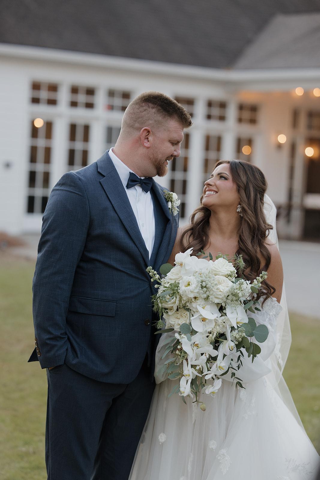 Bride and groom portrait at Little River Farms with cascading orchid bridal bouquet