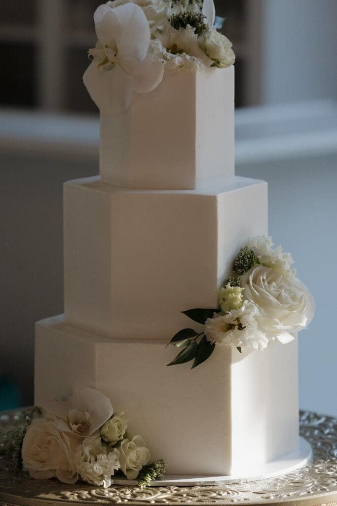 Modern white tiered wedding cake with fresh floral accents
